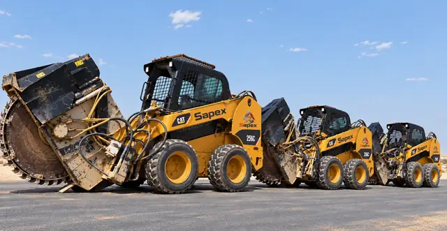 Three narrow-trench cutters with circular saws bearing the Sapex logo, lined up on an asphalt road