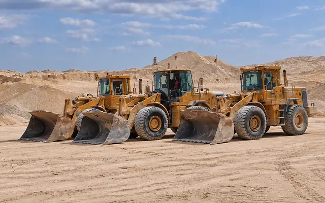 Three wheel loaders lined up in the quarry yard